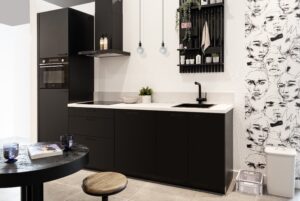 Compacte zwarte keuken met inductiekookplaat en oven Compacte zwarte keuken met inductiekookplaat en oven