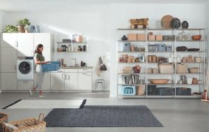 Zijde grijze Nobilia bijkeuken met wandrek keuken Infinity langs een garagewand