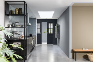 Zwarte industriële keuken met blauwgrijze tegel achterwand, Muren geverfd met Flexa Brave Ground en blauw/grijs tinten)