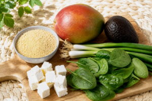 Muhammara couscous salade ingredienten als feta, mango, avocado en baby spinazie