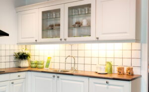 Verlichting onder keukenkastjes achter sierlijst van een landelijke keuken