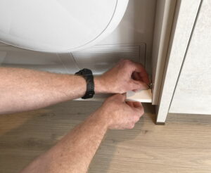 Droger en wasmachine inbouwen stappenplan - vleugelmoertjes losdraaien van frontraam plank Droger en wasmachine inbouwen stappenplan - vleugelmoertjes losdraaien van frontraam plank