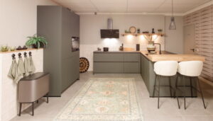 Moderne groene schiereiland keuken met 'spoeleiland' en houten bar Moderne groene schiereiland keuken met 'spoeleiland' en houten bar