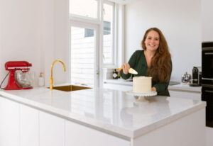 Mat witte keuken met eiland en goudkleurige Quooker Gold en Lanesto spoelbak Gold - Binnenkijker bij trotse klanten Kim & Sander, Haarlem