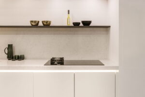 Mat witte keuken met wit blad composiet marmerlook grijs gewolkt met zwarte inductiekookplaat en wok gaspit