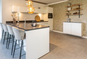 Moderne witte keuken met eiland - wit schiereiland met grijs blad en comfortabele barkrukken