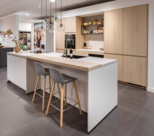 Witte keuken met houten blad - wit kookeiland met houten bar, koffiehoekje en hoge kastenwand
