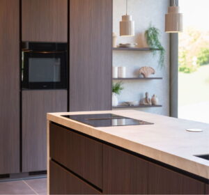 Donkerhouten kookeiland keuken - hoge kastenwand, kookeiland en wandpanelen met marmerlook werkblad Donkerhouten kookeiland keuken - hoge kastenwand, kookeiland en wandpanelen met marmerlook werkblad
