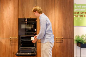 Energielabel checken van een multifunctionele oven in een houten keuken van I-KOOK Energielabel checken van een multifunctionele oven in een houten keuken van I-KOOK