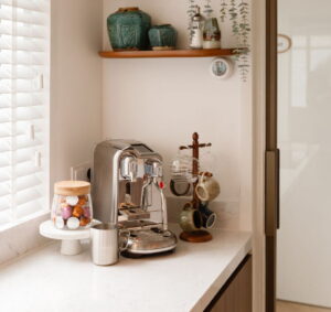 Noten houten keuken met een gezellige koffiehoek en een chroom espressoapparaat